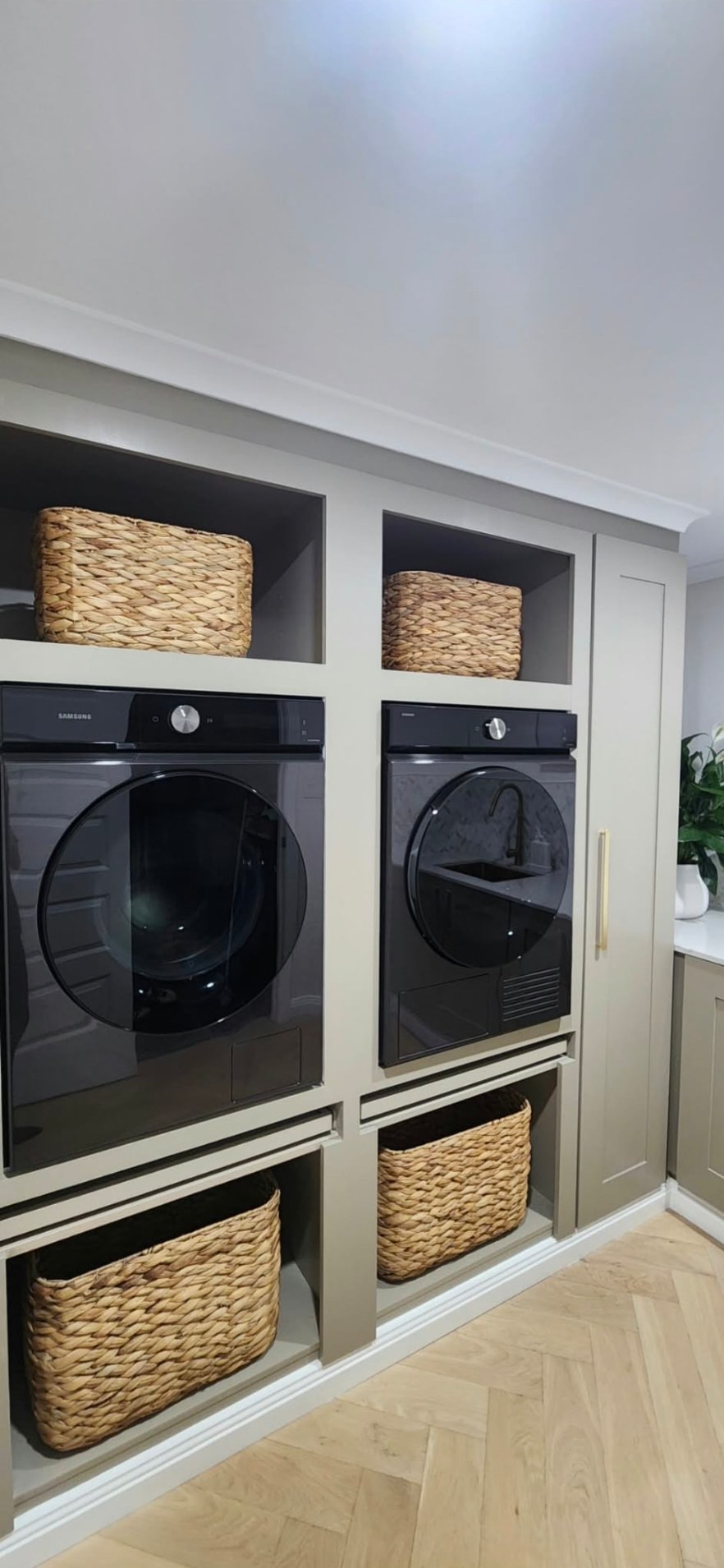 Built-in laundry cabinetry housing a raised washer and dryer