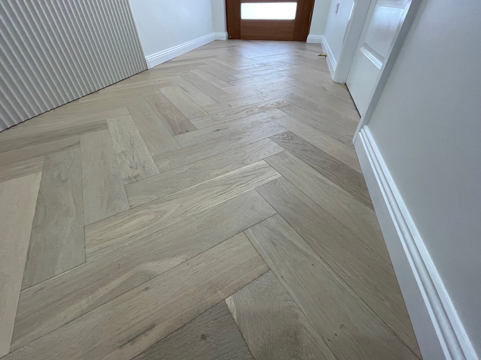 Herringbone oak veneer flooring through a hallway