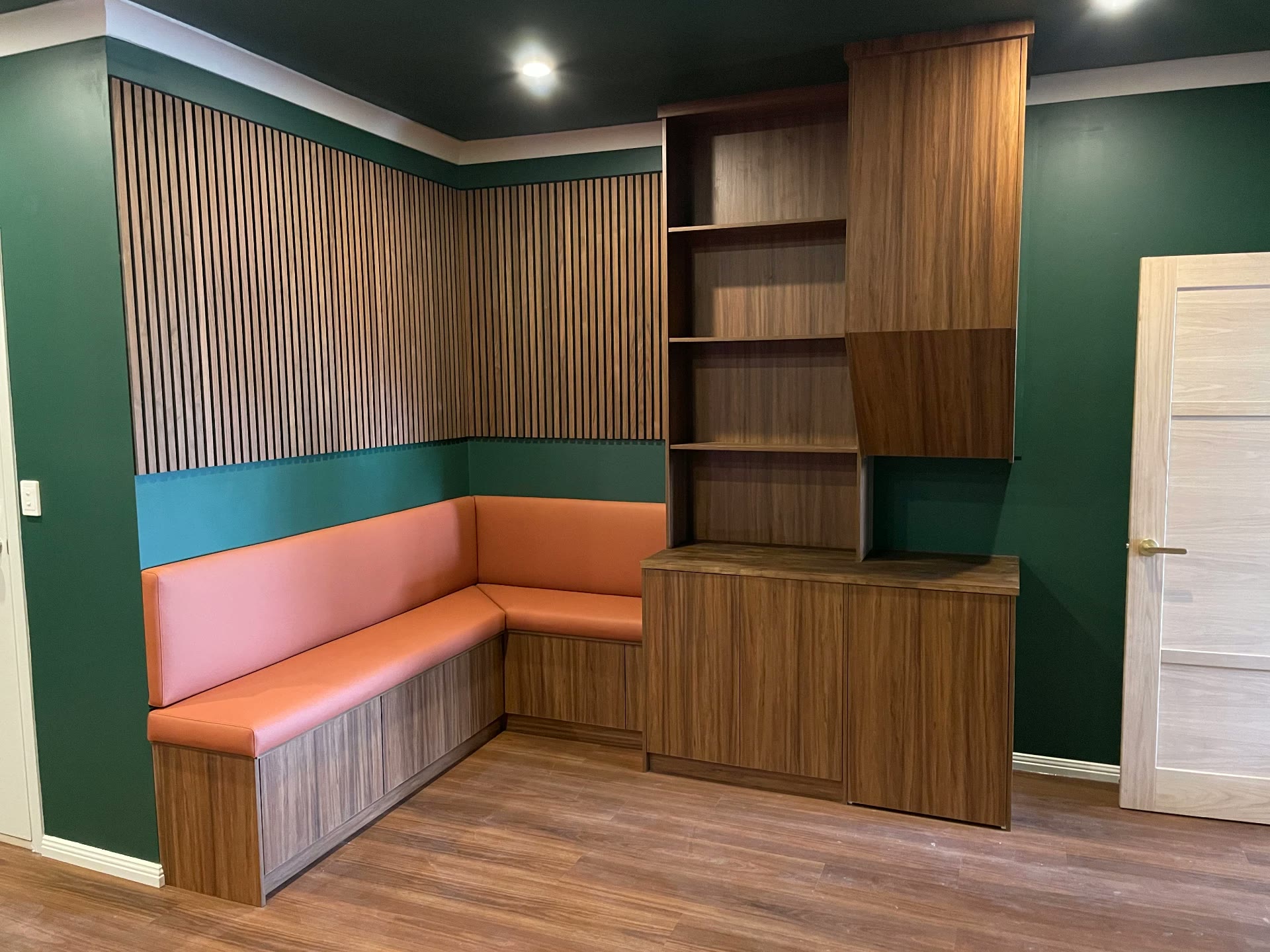 Finished built-in banquette seating, timber-look joinery and slatted batten wall