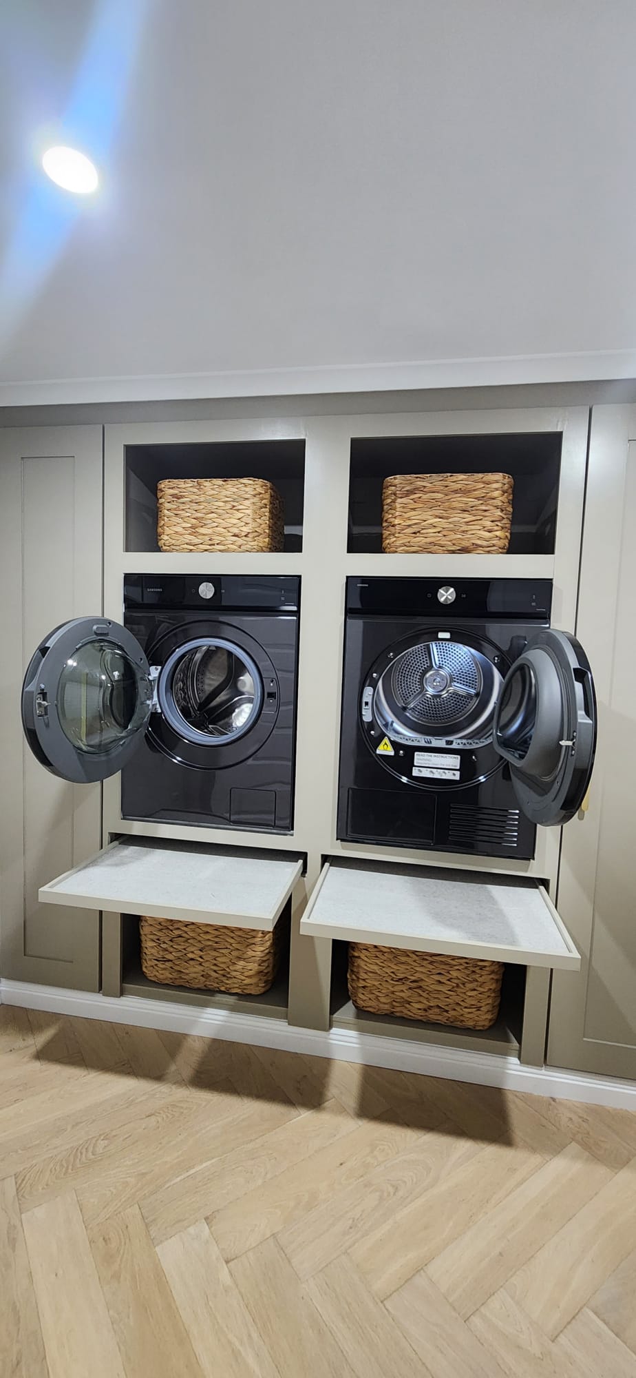 Laundry cabinetry with pull-out shelves beneath the washer and dryer